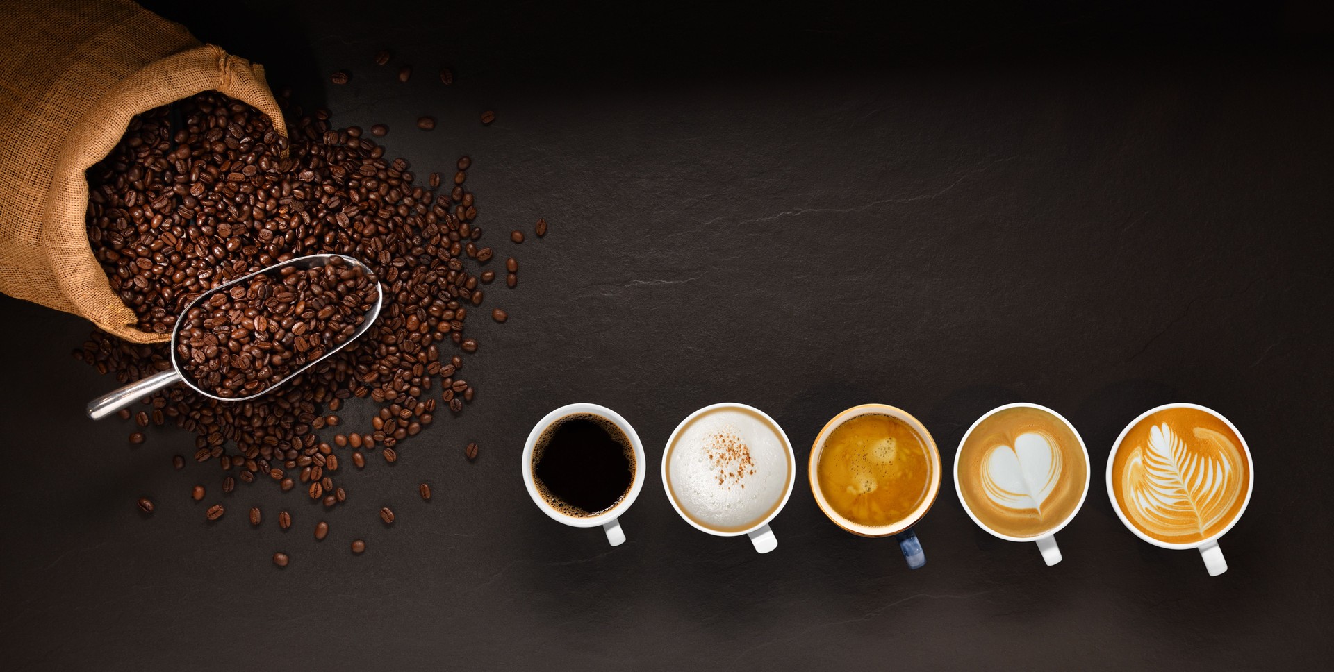 Variety of cups of coffee and coffee beans in burlap sack on black background